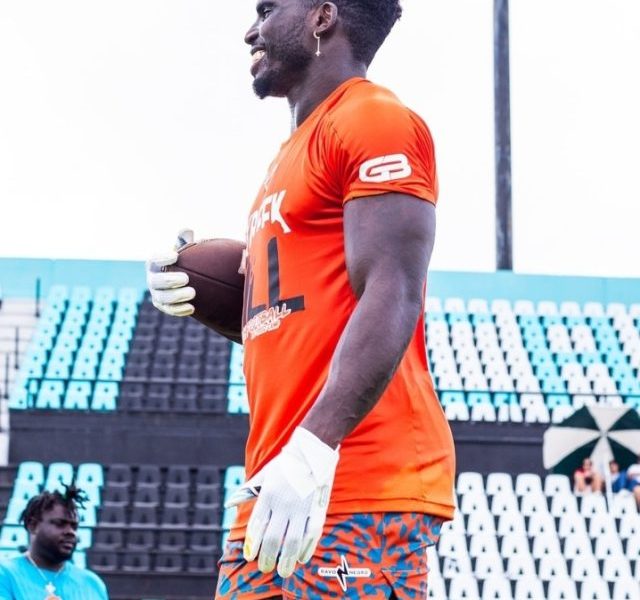 Tyreek Hill holding rugby ball